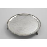 A MID 20TH CENTURY SALVER of shaped circular outline with a gadrooned border and ball & claw feet,