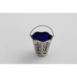 A GEORGE III CREAM PAIL with pierced and embossed sides, a blue glass liner, wavy rim with a