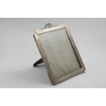 AN EDWARDIAN RECTANGULAR PHOTOGRAPH FRAME with incurved top corners, an applied gold border and a