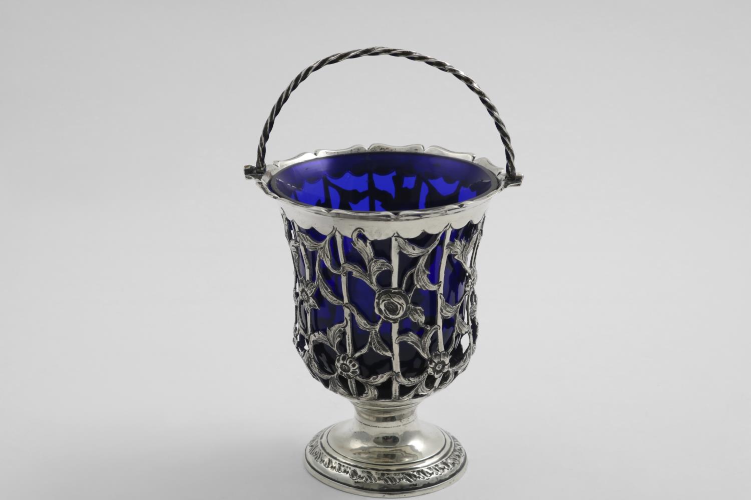 A LATE 18TH CENTURY SWING-HANDLED SUGAR VASE with a shaped rim pierced and chased sides and a vacant