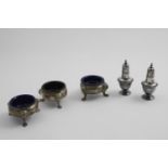 A SET OF THREE GEORGE II SQUAT CIRCULAR SALTS on three lion mask and paw feet, by Edward Wood,