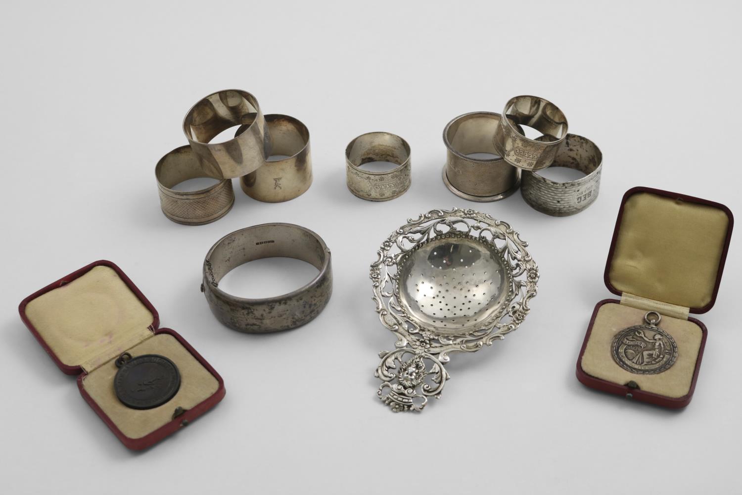 A MIXED LOT:- A pair of Victorian engraved napkin rings, five other napkin rings (with initials/