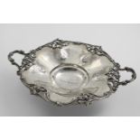 A VICTORIAN TWO-HANDLED DISH of shaped circular outline with a cast openwork border of flowers &