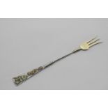 AN EARLY 20TH CENTURY NORTH AMERICAN PICKLE FORK parcelgilt, the flaming terminal with applied 3-