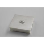 AN ART DECO HANDMADE SMALL RECTANGULAR BOX with a stepped boss on the cover and plain angled feet,