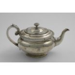 A GEORGE III SCOTTISH TEA POT of compressed circular form with a gadrooned rim, a fruit or bud