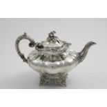 AN EARLY VICTORIAN SCOTTISH PROVINCIAL TEA POT with a shaped circular body, a leafy scroll handle,