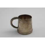 A MID 20TH CENTURY HANDMADE MUG with a tapering body and a hammered finish, decorated around the