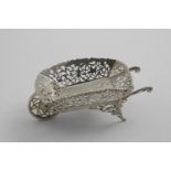AN EDWARDIAN BONBON DISH in the form of a wheelbarrow with pierced, engraved and applied decoration,