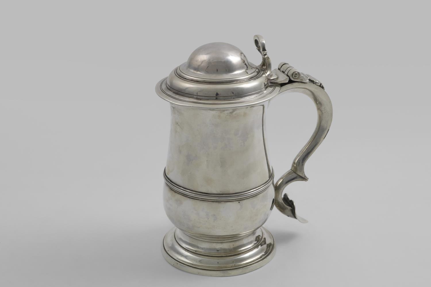 A GEORGE III BALUSTER TANKARD with an applied moulded girdle, a spreading foot, the domed cover with