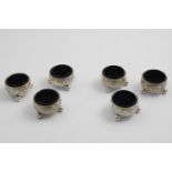 A SET OF SIX VICTORIAN SQUAT CIRCULAR SALTS on ball feet with chased floral scrolls around the sides