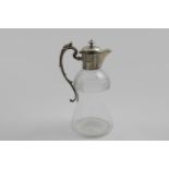 A LATE VICTORIAN MOUNTED CUT-GLASS CLARET JUG with a campana-shaped body, decorative scroll handle