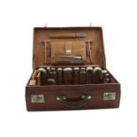 AN EARLY 20TH CENTURY CROCODILE LEATHER DRESSING CASE fitted with the following:- A spirit flask,
