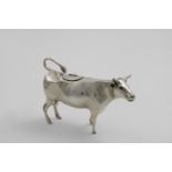 A 20TH CENTURY DUTCH COW CREAMER with a pull-off head, gem-set eyes and a hinged cover on its back