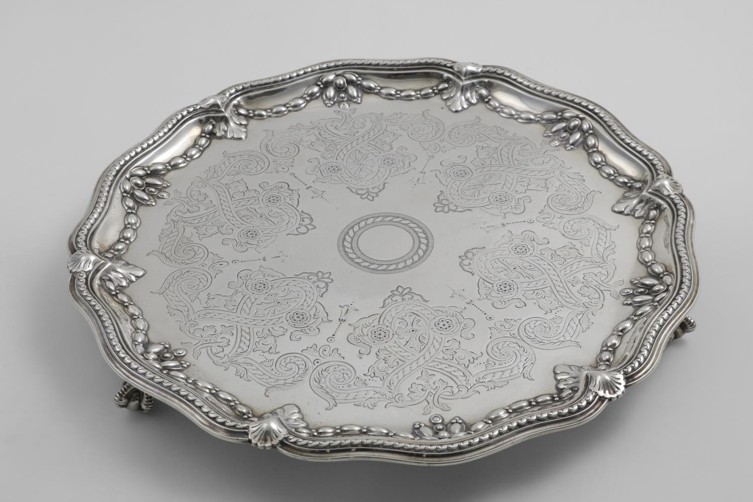 A VICTORIAN ENGRAVED SALVER of shaped circular outline with a moulded border and embossed festoons