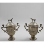 HUNTING:- A matched pair of early 20th century two-handled cups and covers with chased formal