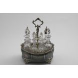 A VICTORIAN CRUET FRAME with three mounted and four stoppered, cut-glass bottles, engraved sides, an