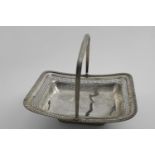 A GEORGE III CAKE BASKET rectangular with a reeded swing handle and a tongue & dart border, the