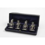 A RARE CASED SET OF FOUR CAST MENU CARD HOLDERS on circular bases; two in the form of Mr Punch and