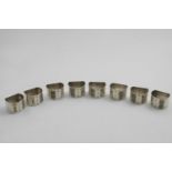 A LATE 20TH CENTURY SET OF EIGHT NAPKIN RINGS with flat bases, each with an applied domino and a row
