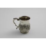 A LATE VICTORIAN BALUSTER MUG with embossed decoration around the lower body, a vacant cartouche and