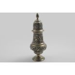 A LATE VICTORIAN LARGE SUGAR CASTER with embossed decoration, a flame finial and a vacant cartouche,