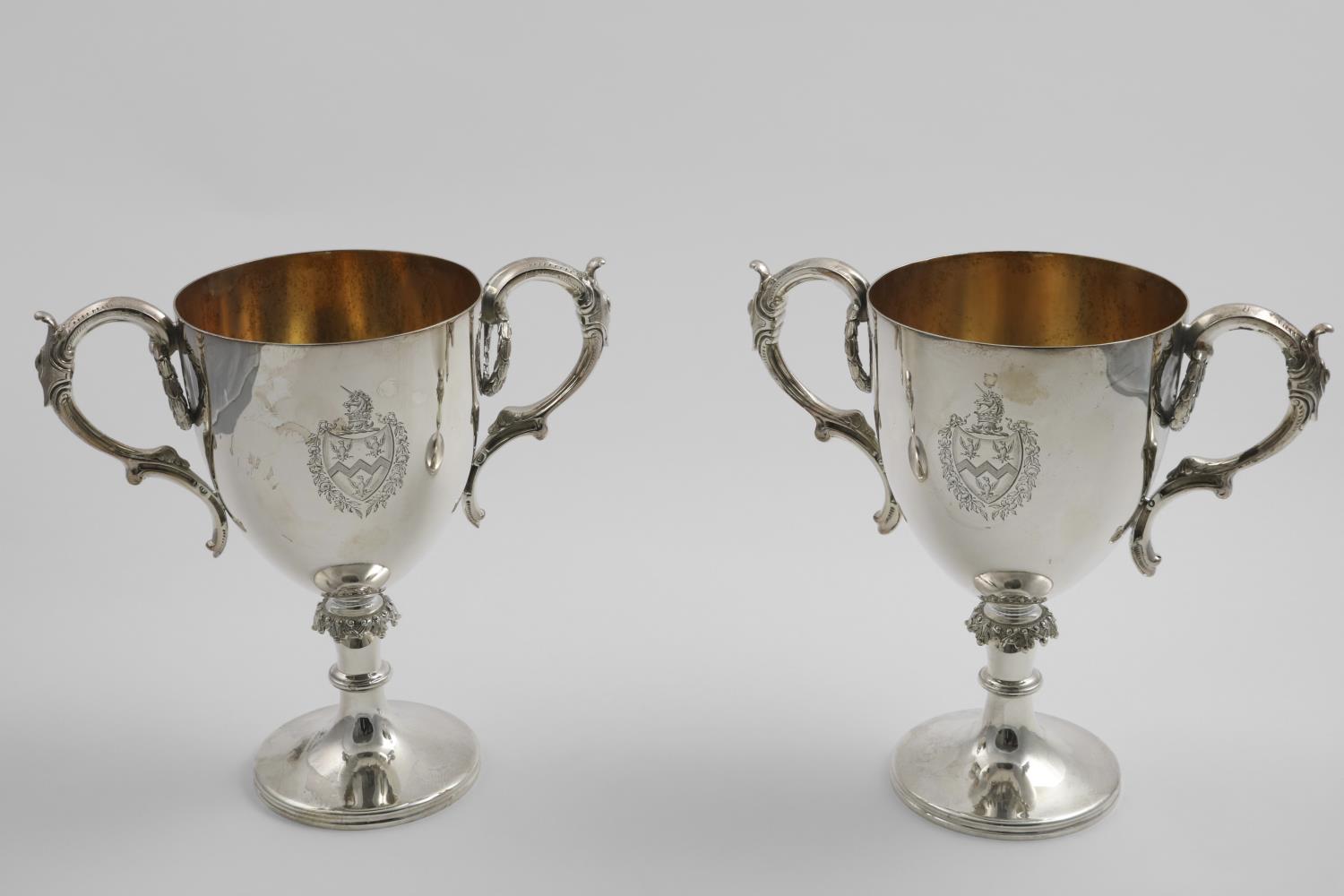A PAIR OF VICTORIAN ELECTROPLATED TROPHY CUPS with gilt interiors and an engraved coat of arms on