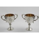 A PAIR OF VICTORIAN ELECTROPLATED TROPHY CUPS with gilt interiors and an engraved coat of arms on