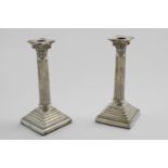 A PAIR OF EARLY 20TH CENTURY CANDLESTICKS on stepped square bases with bead borders, fluted