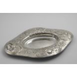 BY GILBERT MARKS:- A late Victorian handmade dish of shaped oval outline with a repousse-work