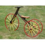 A Child's Wooden-Framed Vélocipède. A tricycle with a 25-inch steering and driving wheel, wooden