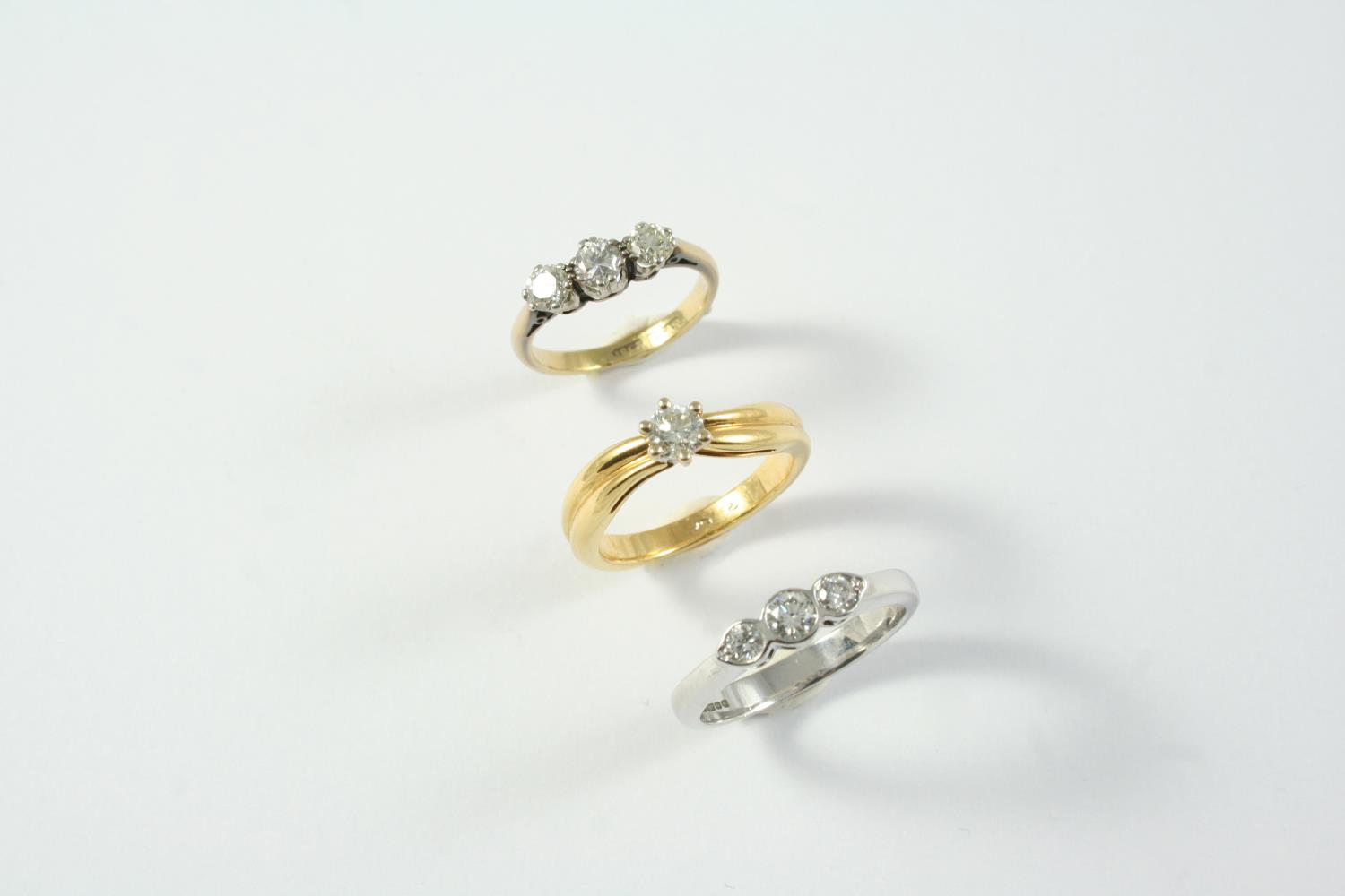 A DIAMOND SOLITAIRE RING set with a circular-cut diamond in yellow gold, size L 1/2, together with a