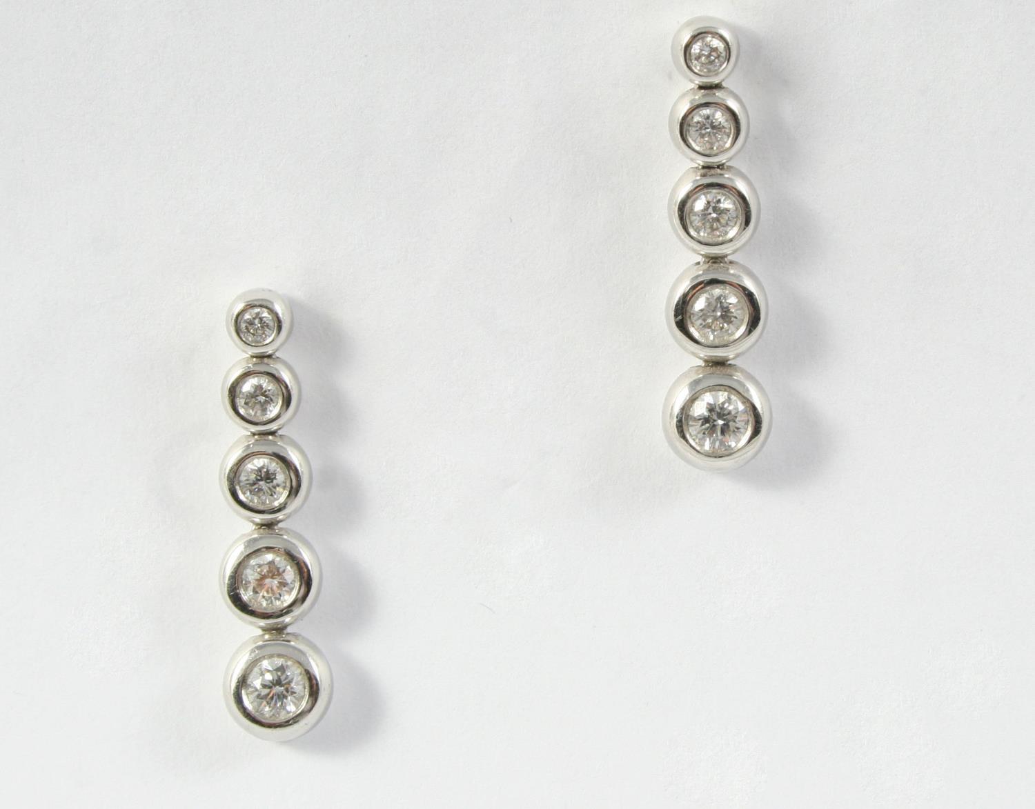 A PAIR OF DIAMOND DROP EARRINGS each earring mounted with five graduated circular-cut diamonds in