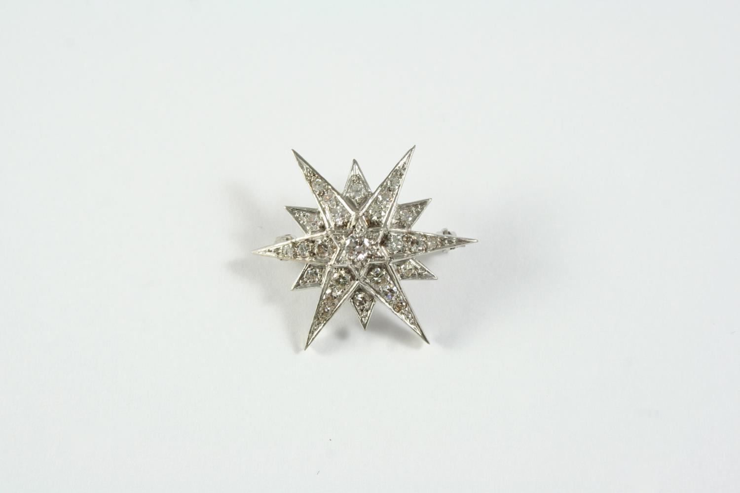 A DIAMOND STAR BROOCH mounted with graduated single-cut diamonds, in 18ct white gold, 3cm wide