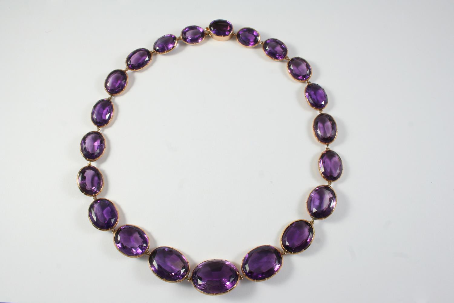 A VICTORIAN AMETHYST RIVIERE NECKLACE the graduated oval-shaped amethysts in gold cut down collet