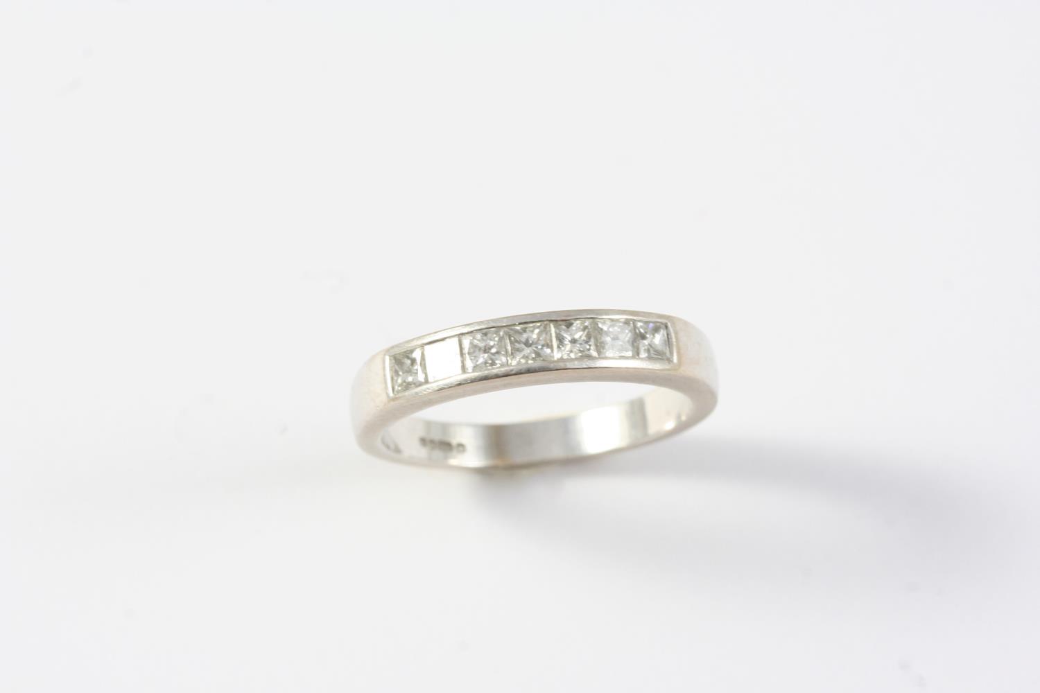 A DIAMOND HALF HOOP RING mounted with seven square-shaped diamonds in 18ct white gold. size P 1/2