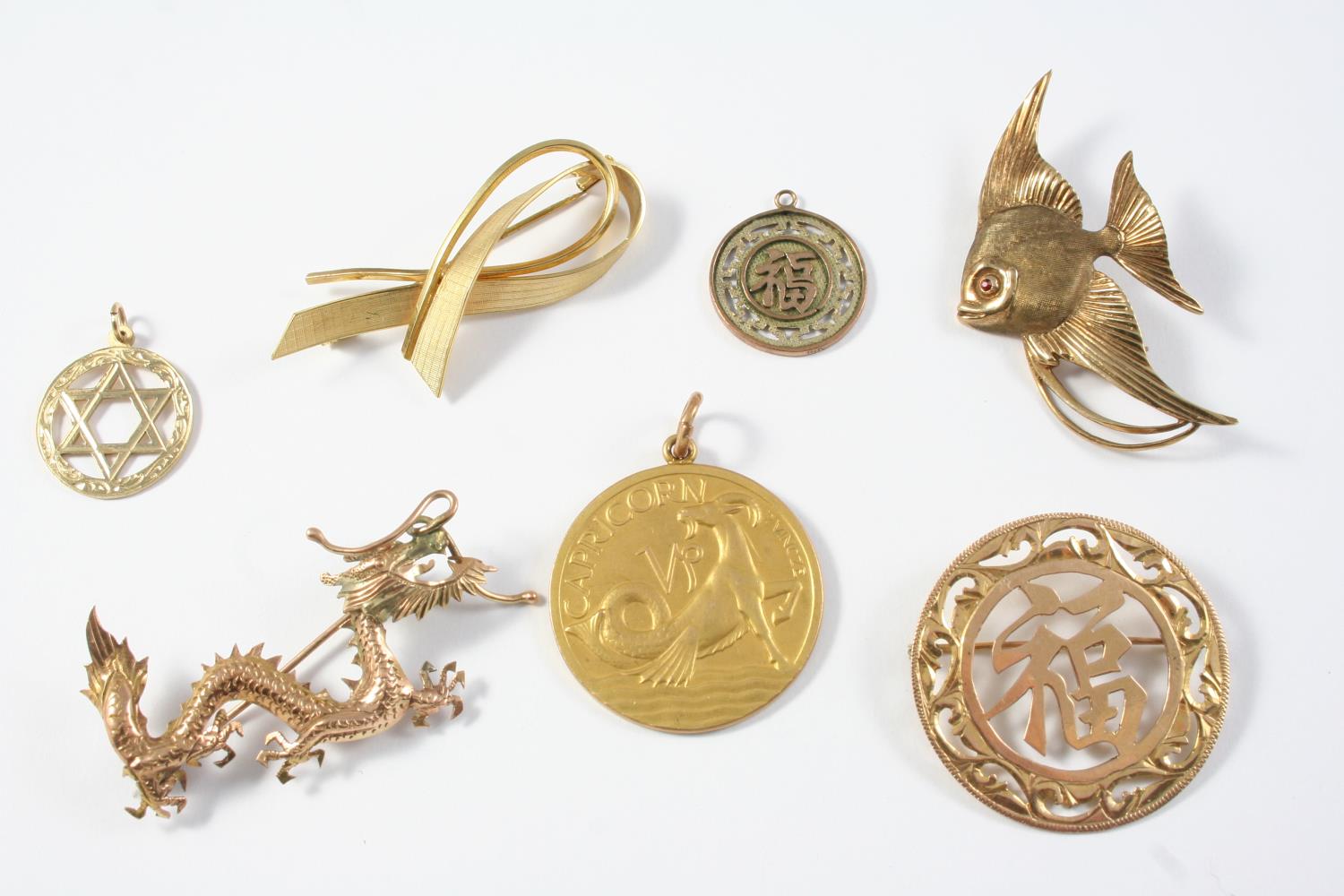 A QUANTITY OF GOLD JEWELLERY including a 9ct gold Capricorn disc pendant, a 9ct gold ribbon