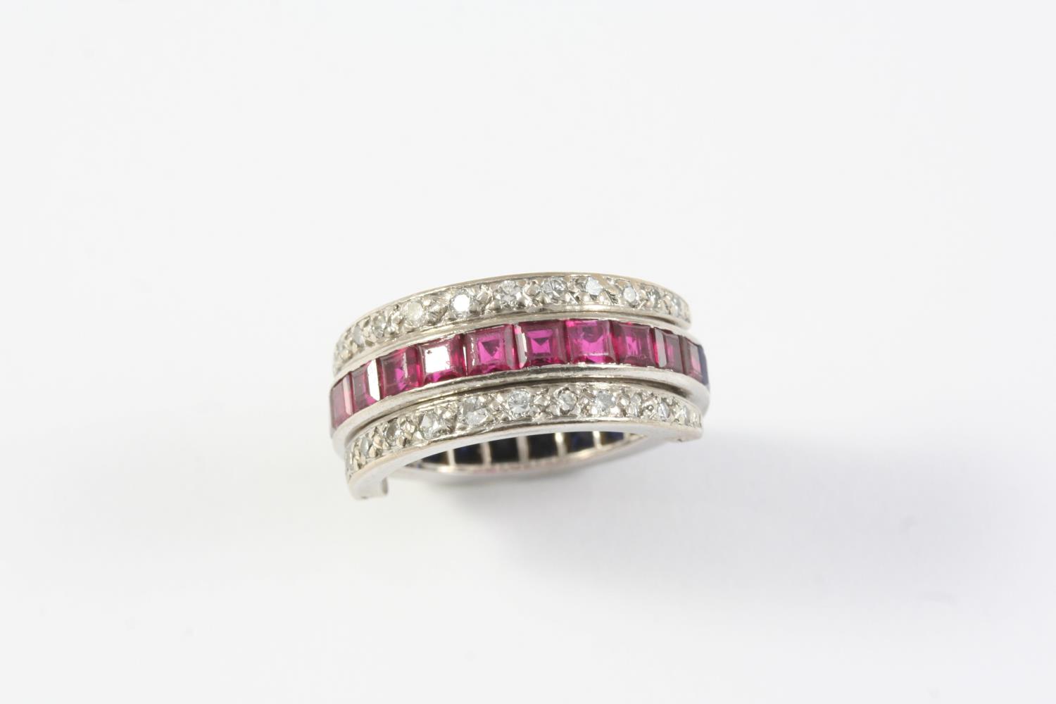 A RUBY, SAPPHIRE AND DIAMOND SWIVEL ETERNITY RING millegrain set with circular-cut diamonds and with