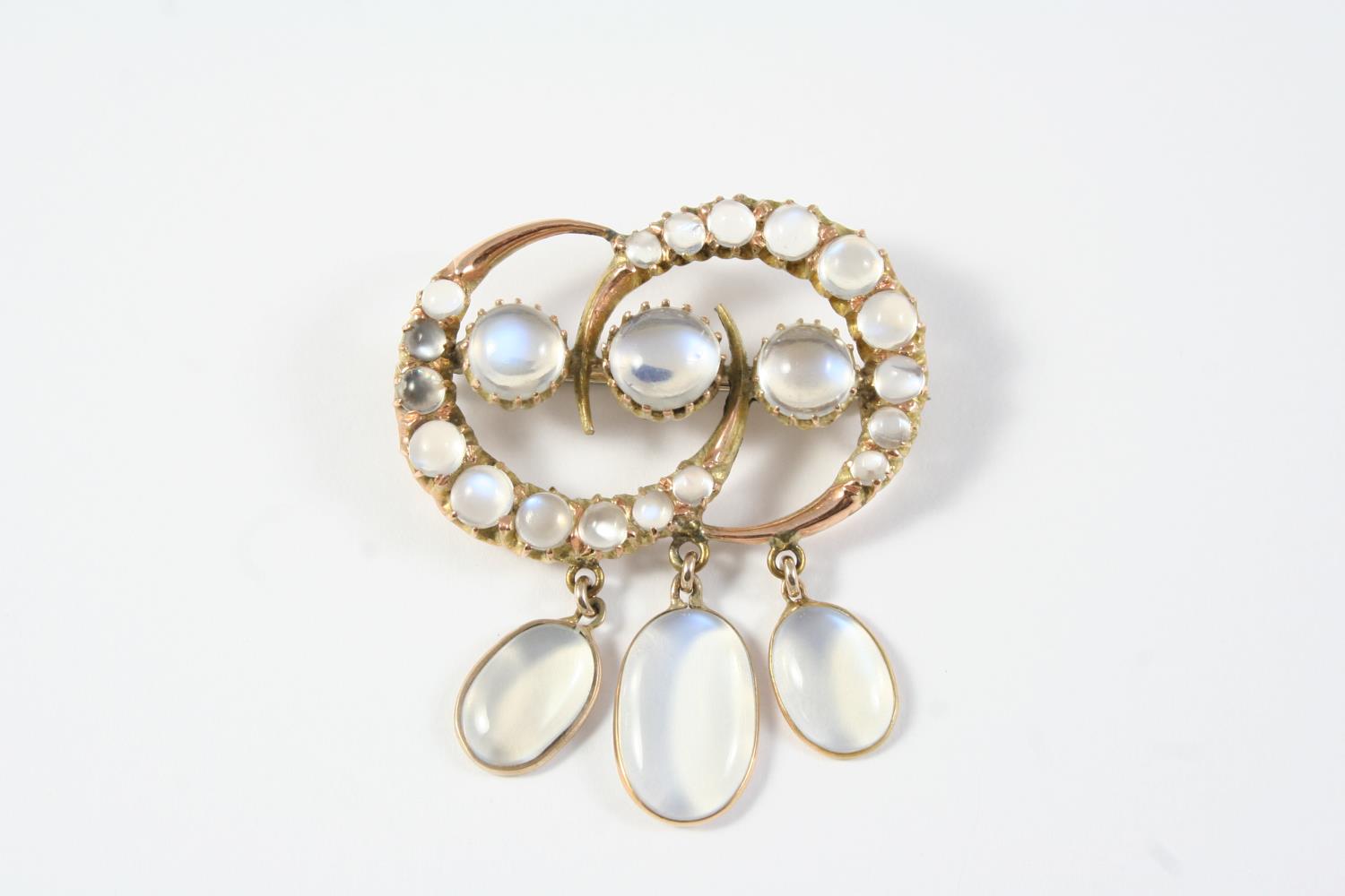 A MOONSTONE AND GOLD BROOCH the three circular moonstones are set within a surround of two