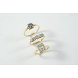 A DIAMOND CLUSTER RING centred with three baguette-cut diamonds within a border of single-cut and