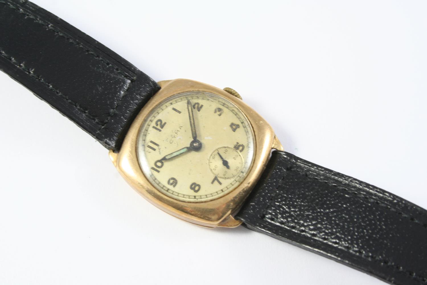 A GOLD WRISTWATCH BY CYMA the circular dial in a cushion shaped case, with Arabic numerals and