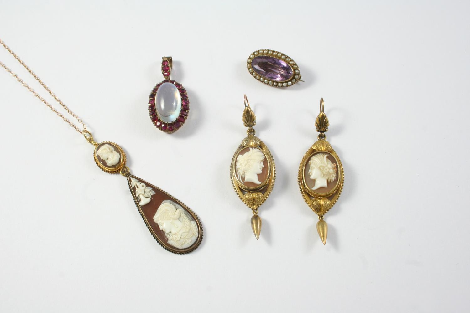 A MOONSTONE AND GARNET CLUSTER PENDANT the oval shaped cabochon moonstone is set within a surround