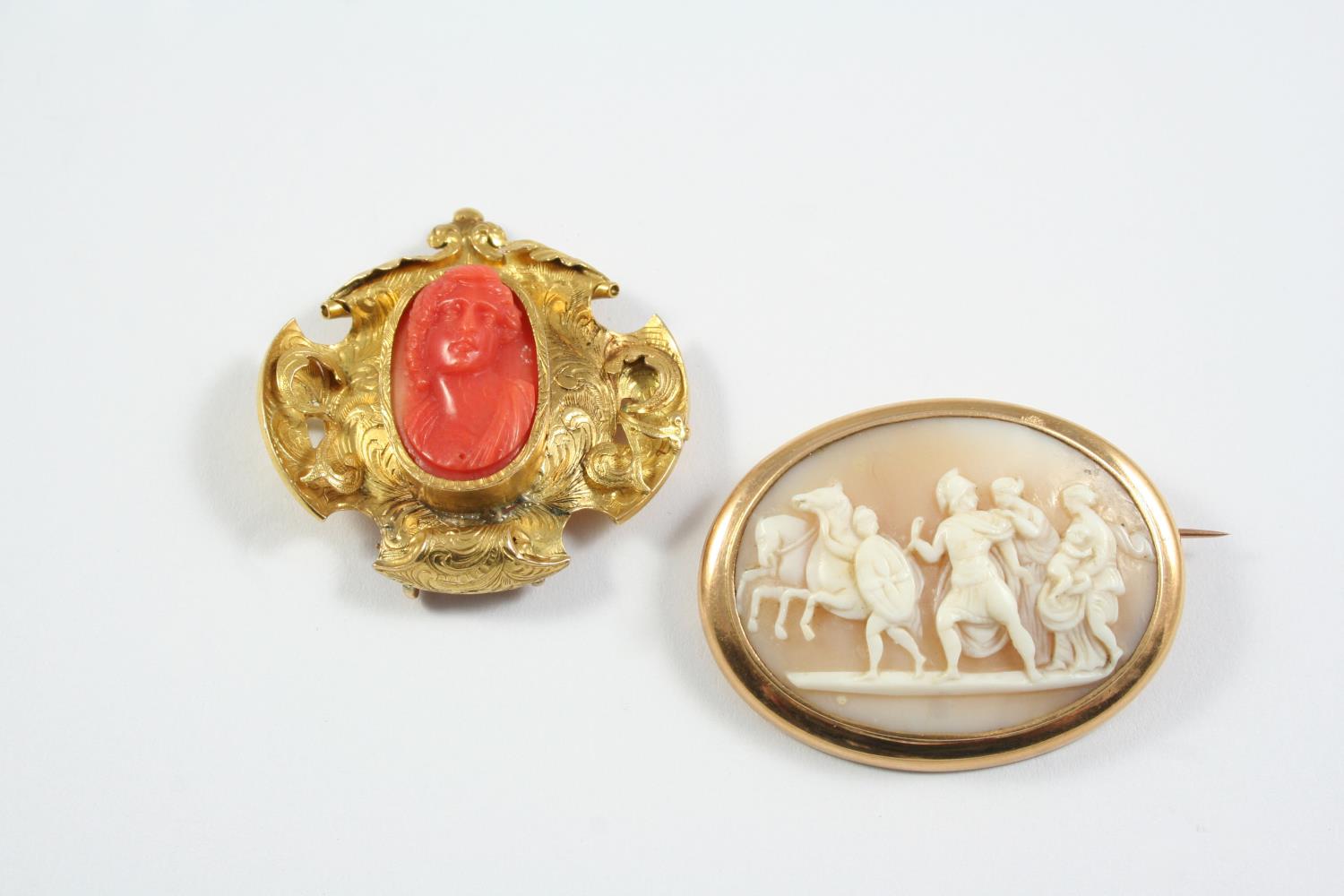A CARVED CORAL CAMEO BROOCH depicting a classical woman, mounted in an ornate gold frame, 4cm