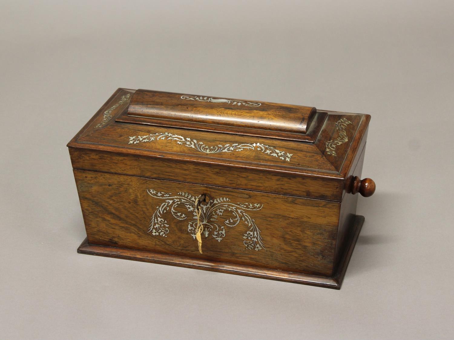 A REGENCY ROSEWOOD AND MOTHER OF PEARL INLAID TEA CADDY. A sarcophagus shaped Regency rosewood tea