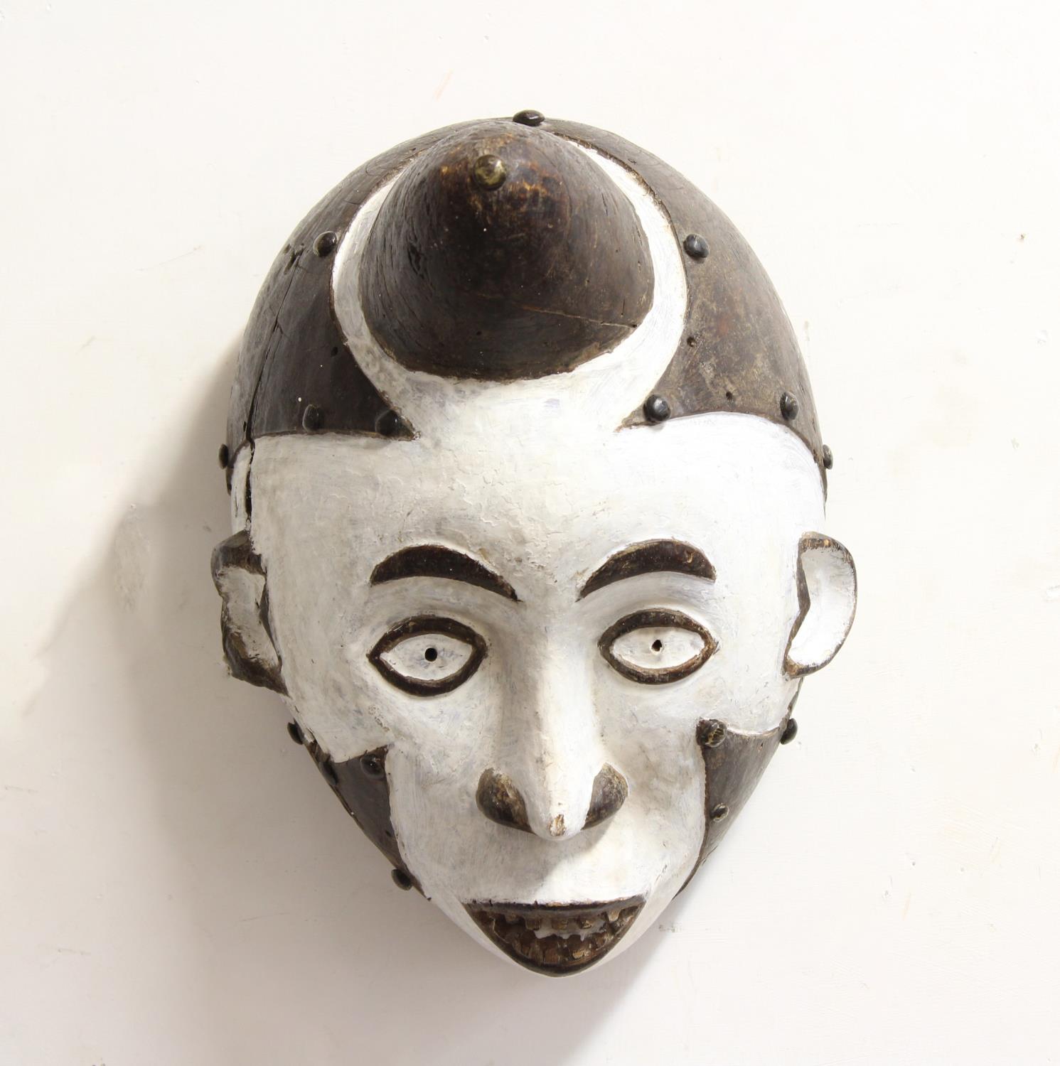 AFRICAN TRIBAL ART: Punu mask, West Africa, with a white painted face, black coiffeur and metal