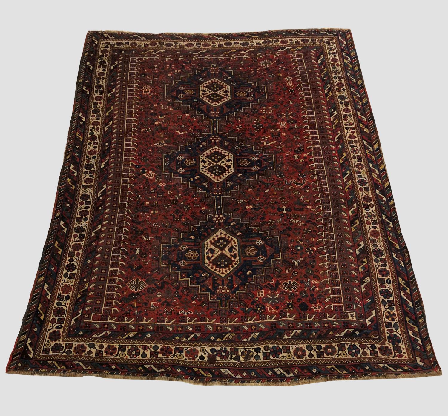 A KHAMSEH CARPET, South West Iran, c.1920, the madder field richly decorated with tribal motifs,