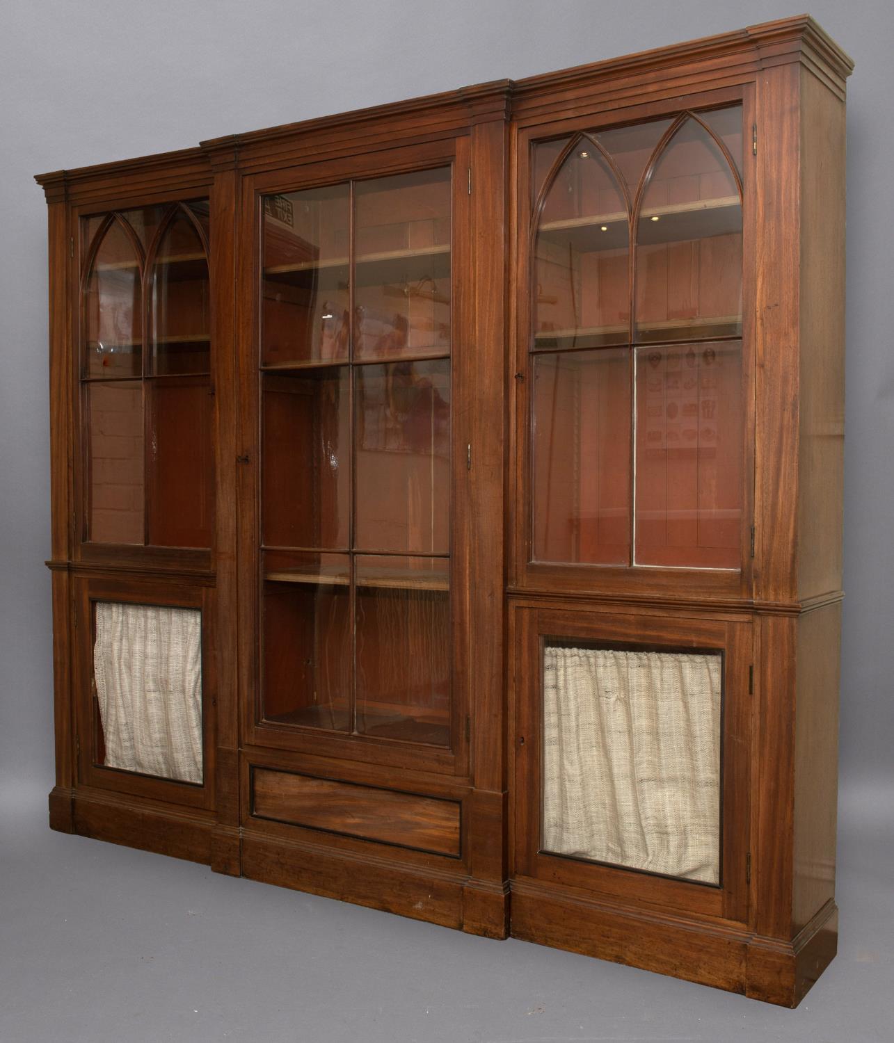 A LATE GEORGE III MAHOGANY LIBRARY BOOKCASE. With a broad central door with six glass panels