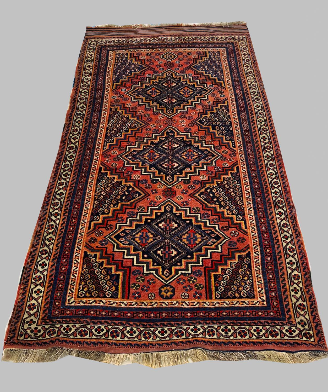 AN AFSHAR RUG, c.1910, South East Iran, the pale brick red field with three stepped indigo