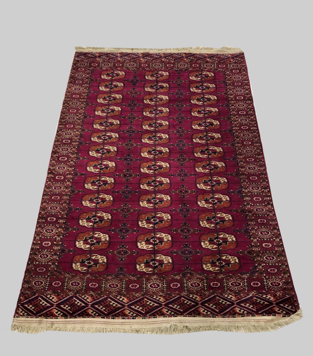 A TEKKE RUG, Emirate of Bukhara, c.1910, the raspberry field with three columns of quartered guls