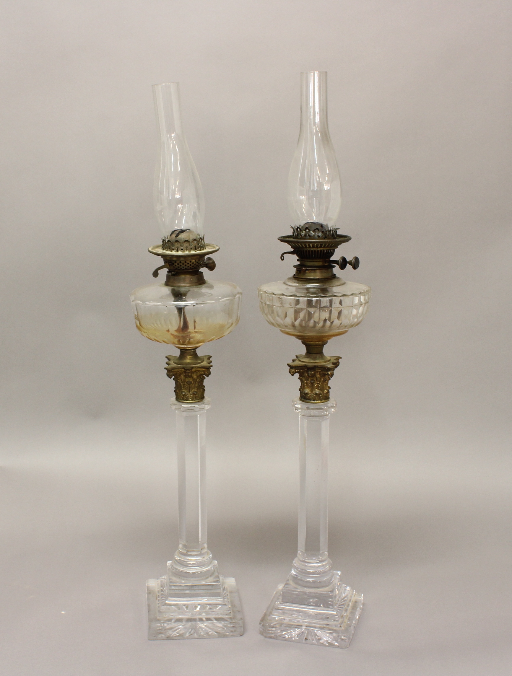 A NEAR PAIR OF VICTORIAN GLASS COLUMN STANDARD LAMPS. Each with hexagonal glass column supports